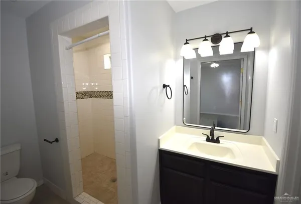 a bathroom with a sink vanity mirror and toilet