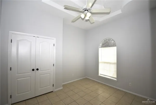 an empty room with windows and fan