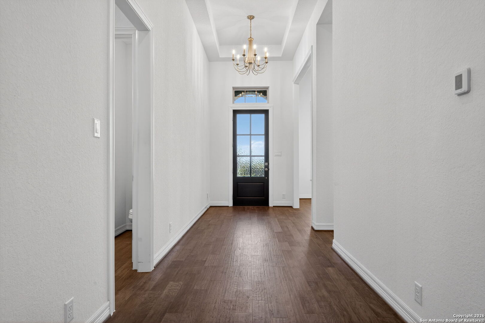 28640 Bull Gate Boerne, TX 78015 - Photo 9 of 40 a view of a hallway with wooden floor and a chandelier