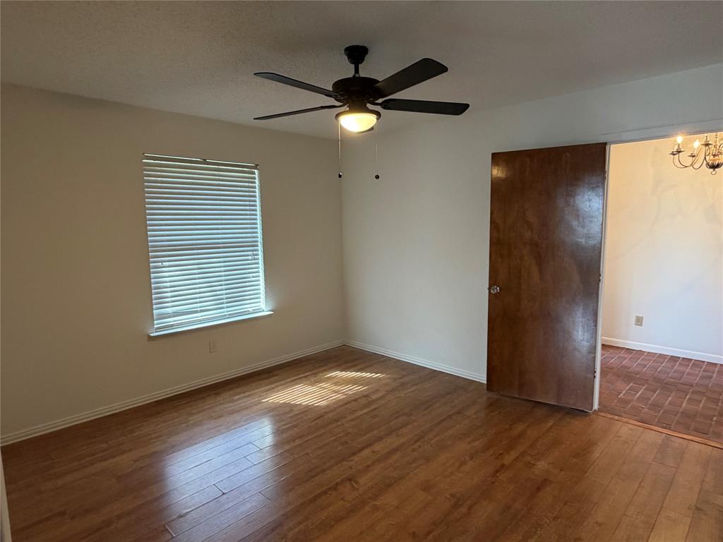 314 West 5th Street Springtown, TX 76082 - Photo 11 of 21 a view of an empty room with wooden floor and a window