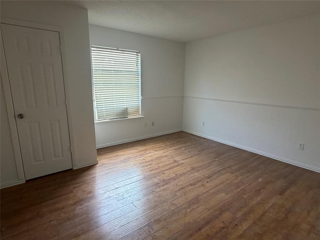 314 West 5th Street Springtown, TX 76082 - Photo 12 of 21 an empty room with wooden floor and windows