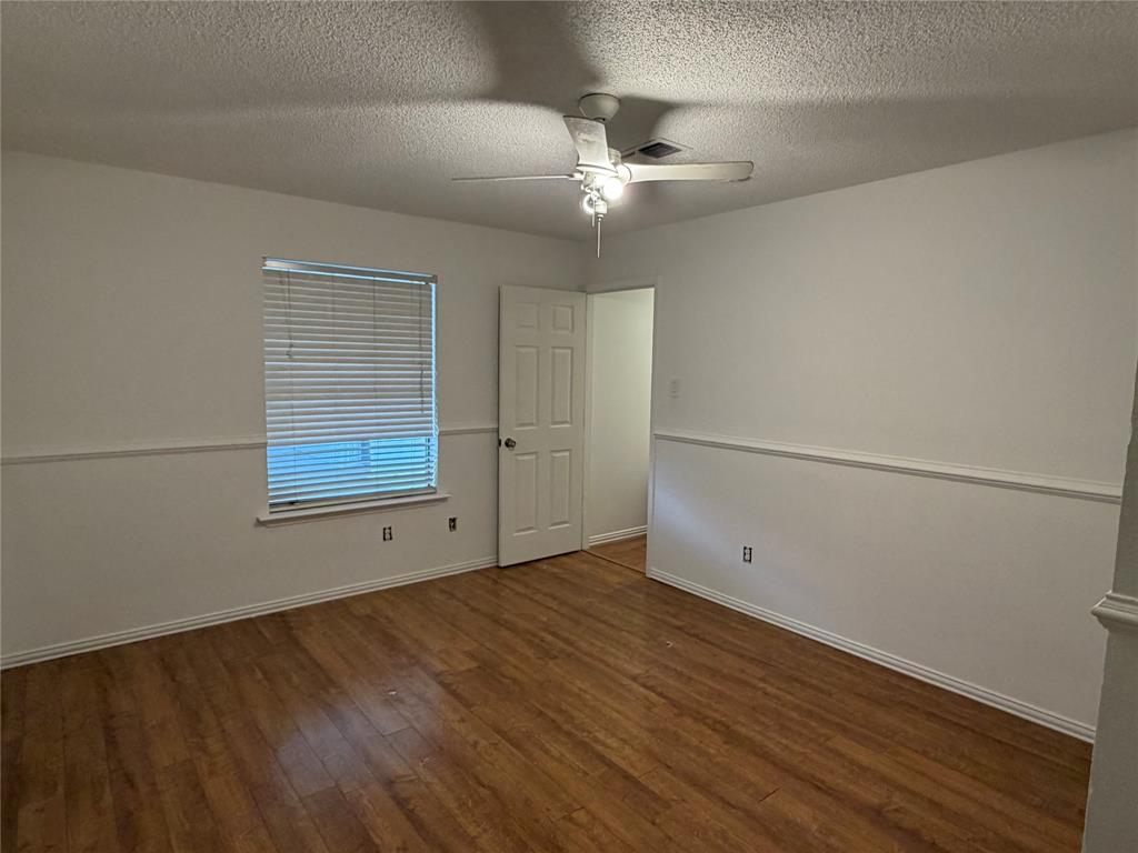 314 West 5th Street Springtown, TX 76082 - Photo 14 of 21 an empty room with wooden floor closet and windows