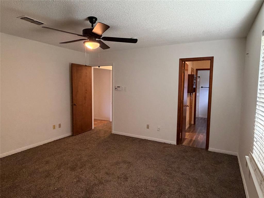 314 West 5th Street Springtown, TX 76082 - Photo 17 of 21 an empty room with ceiling fan and window