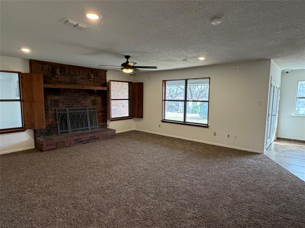 314 West 5th Street Springtown, TX 76082 - Photo 5 of 21 an empty room with windows and fireplace
