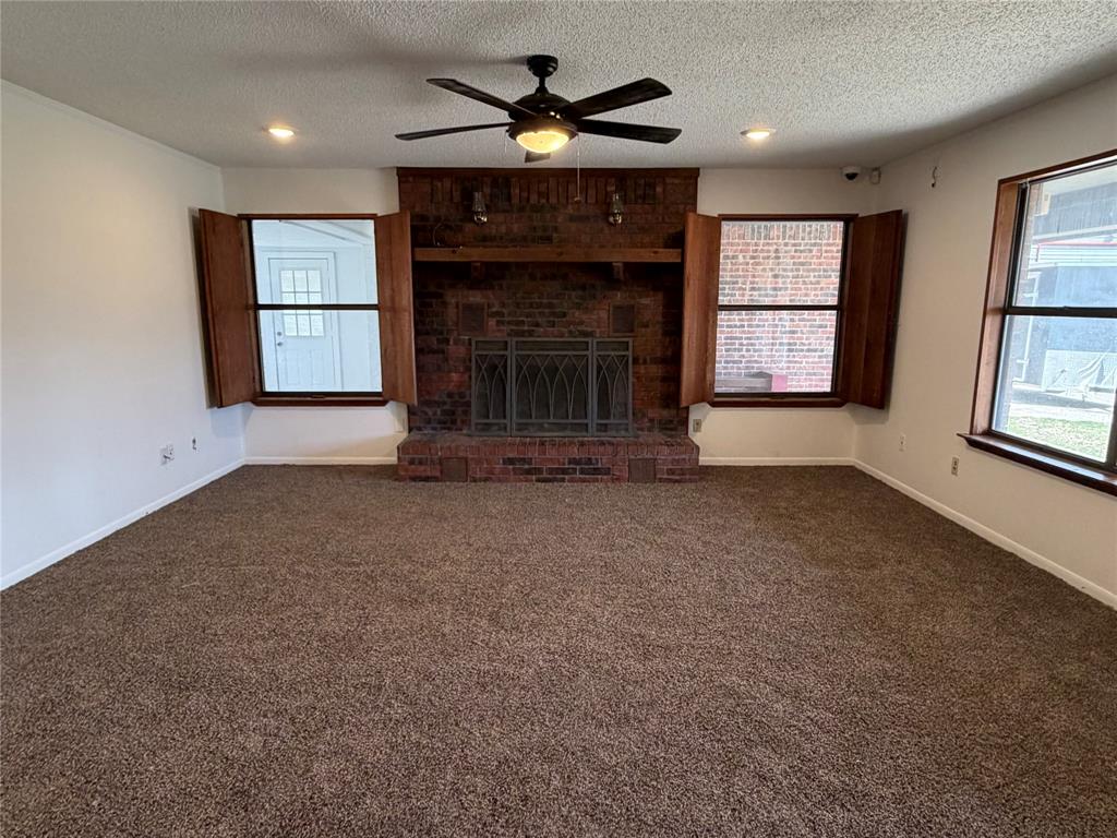 314 West 5th Street Springtown, TX 76082 - Photo 6 of 21 an empty room with windows and fireplace