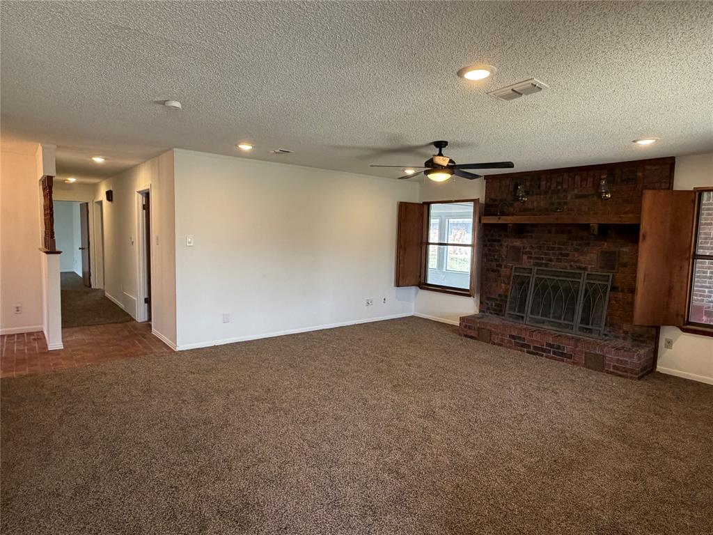 314 West 5th Street Springtown, TX 76082 - Photo 7 of 21 a view of empty room with a fireplace and window