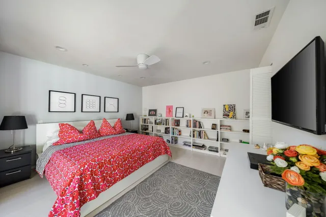 a bedroom with a bed furniture and a flat tv screen