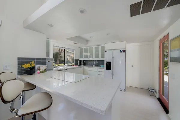 a kitchen with stainless steel appliances granite countertop a sink refrigerator and cabinets