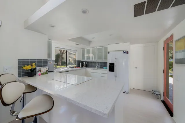 a kitchen with stainless steel appliances granite countertop a sink refrigerator and cabinets