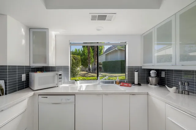 a kitchen with sink a window and cabinets