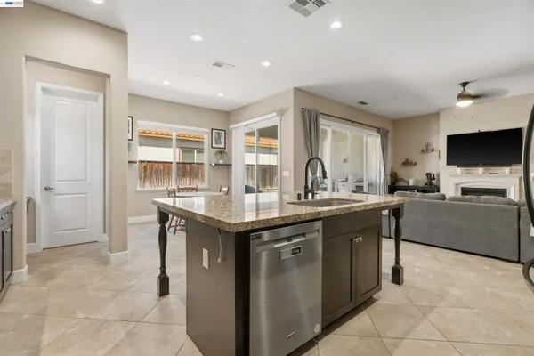a spacious bedroom with a large bed a chandelier and windows