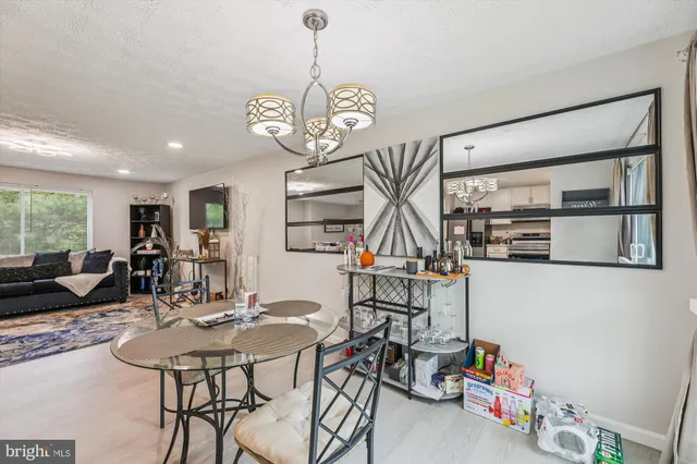 a view of a dining room with furniture a chandelier and wooden floor