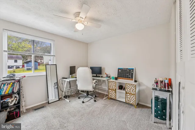 a view of a workspace with furniture and a window