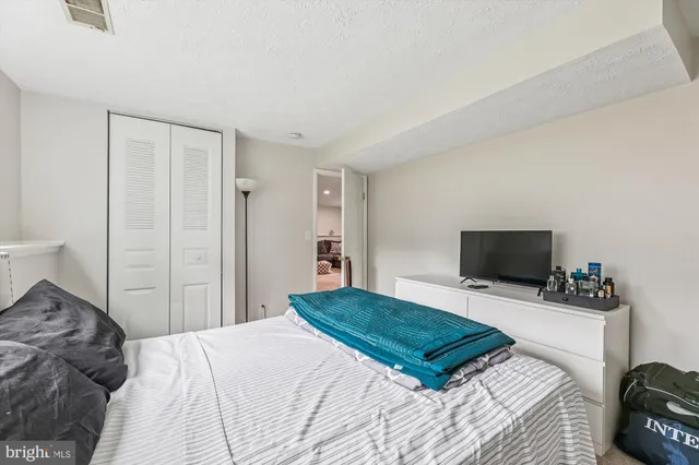 a bedroom with a bed and a painting on the wall