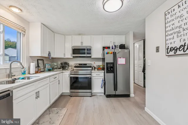 a kitchen with stainless steel appliances a refrigerator sink and microwave