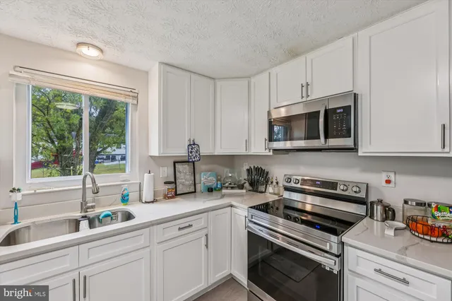 a kitchen with appliances a sink and cabinets