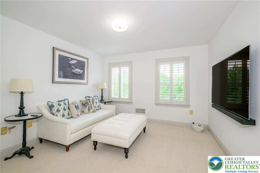 217 Gower Road Nazareth, PA 18064 - Photo 27 of 44 A quiet living area featuring plush carpeting and white plantation shutters framing verdant outdoor views.