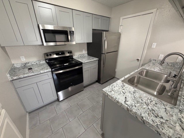 2277 South Kirkwood Road, Unit 104 Houston, TX 77077 - Photo 4 of 12 a kitchen with a sink stove and refrigerator