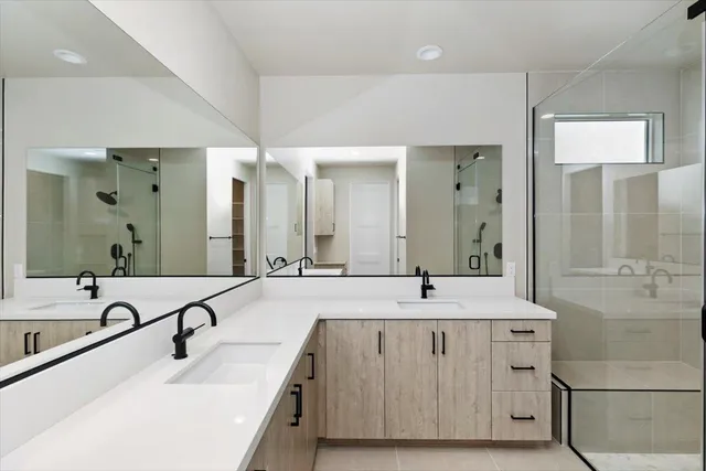 a bathroom with double vanity sinks and a large mirror