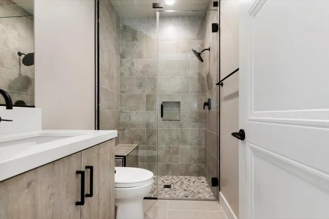 a bathroom with a sink a toilet and shower