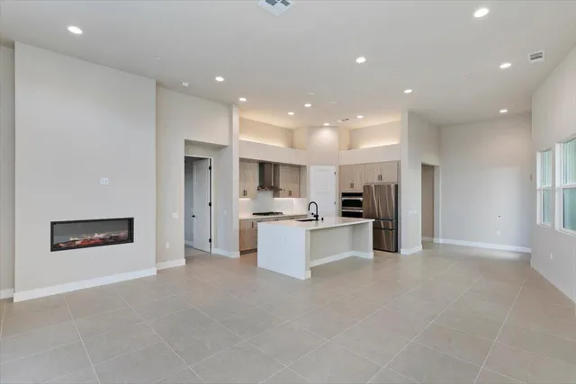a large kitchen with stainless steel appliances kitchen island a large counter top and a sink