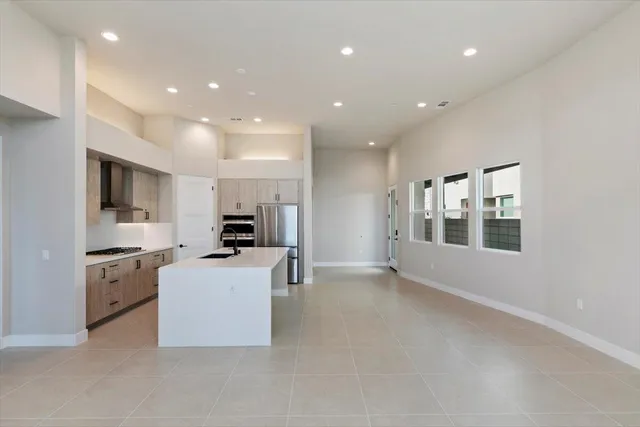 a kitchen with stainless steel appliances kitchen island granite countertop a stove top oven a sink a dining table and chairs