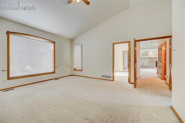 15091 Ridgefield Lane Colorado Springs, CO 80921 - Photo 27 of 35 Carpeted spare room featuring ceiling fan and high vaulted ceiling