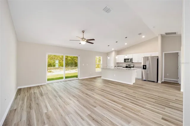a view of empty room with wooden floor and windows