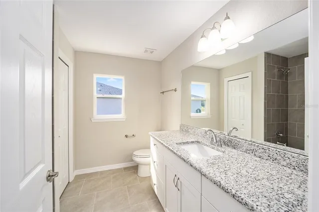 a bathroom with a granite countertop sink and a mirror