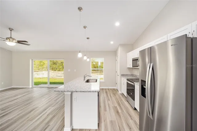 a kitchen with stainless steel appliances a refrigerator and a stove top oven