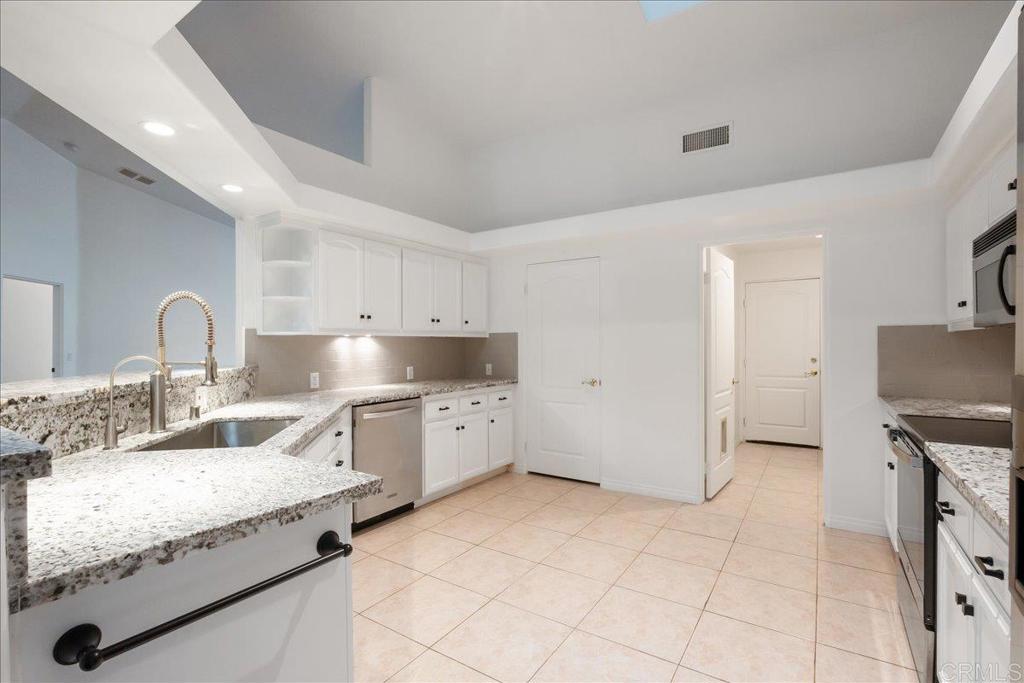 9144 Old Castle Road Valley Center, CA 92082 - Photo 12 of 48 a large kitchen with granite countertop a sink and a stove top oven