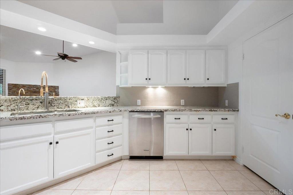 9144 Old Castle Road Valley Center, CA 92082 - Photo 14 of 48 a kitchen with granite countertop white cabinets and stainless steel appliances