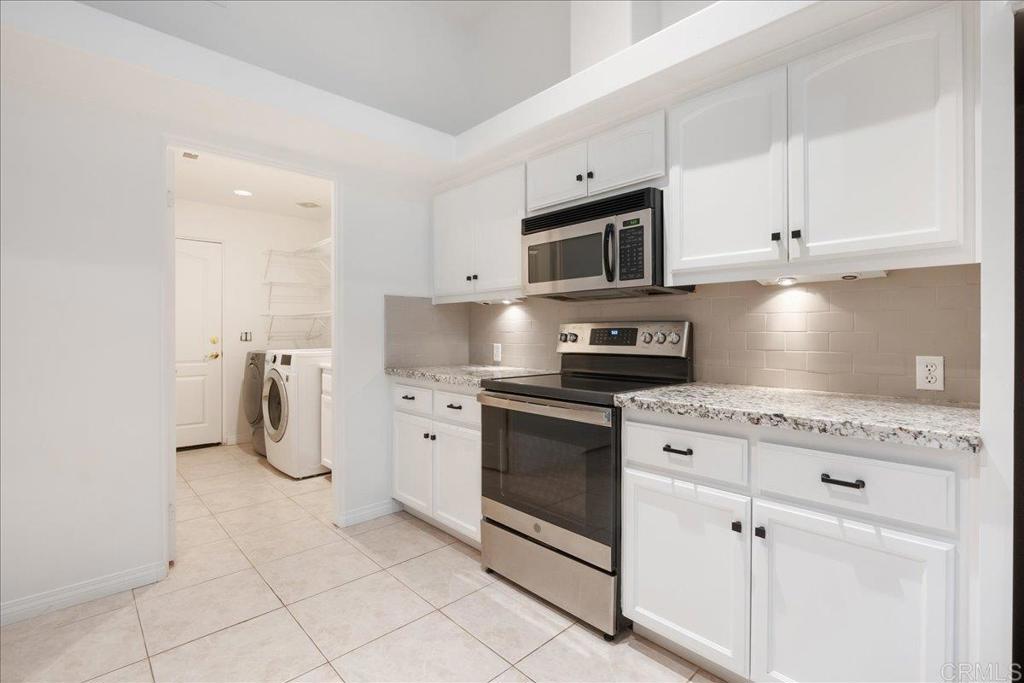 9144 Old Castle Road Valley Center, CA 92082 - Photo 15 of 48 a kitchen with stainless steel appliances granite countertop a stove a sink and a refrigerator