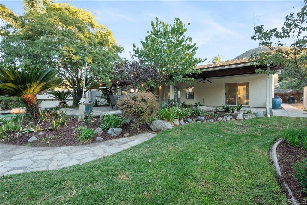 9144 Old Castle Road Valley Center, CA 92082 - Photo 34 of 48 a view of a backyard with table and chairs potted plants and large tree