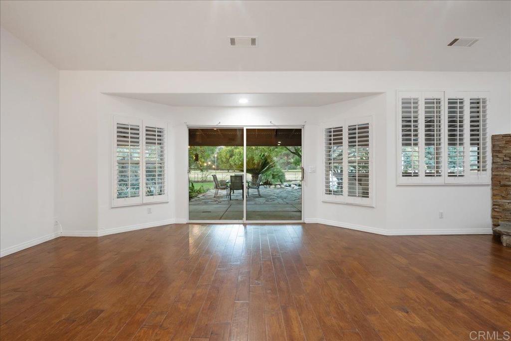9144 Old Castle Road Valley Center, CA 92082 - Photo 5 of 48 a view of an empty room with wooden floor and a window