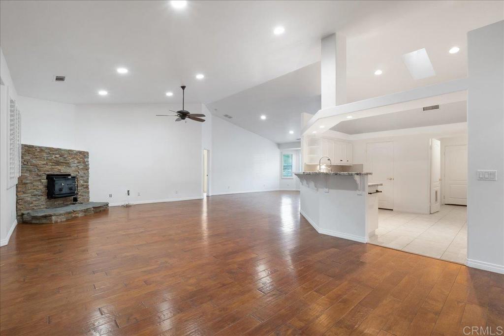 9144 Old Castle Road Valley Center, CA 92082 - Photo 7 of 48 an empty room with wooden floor and a kitchen