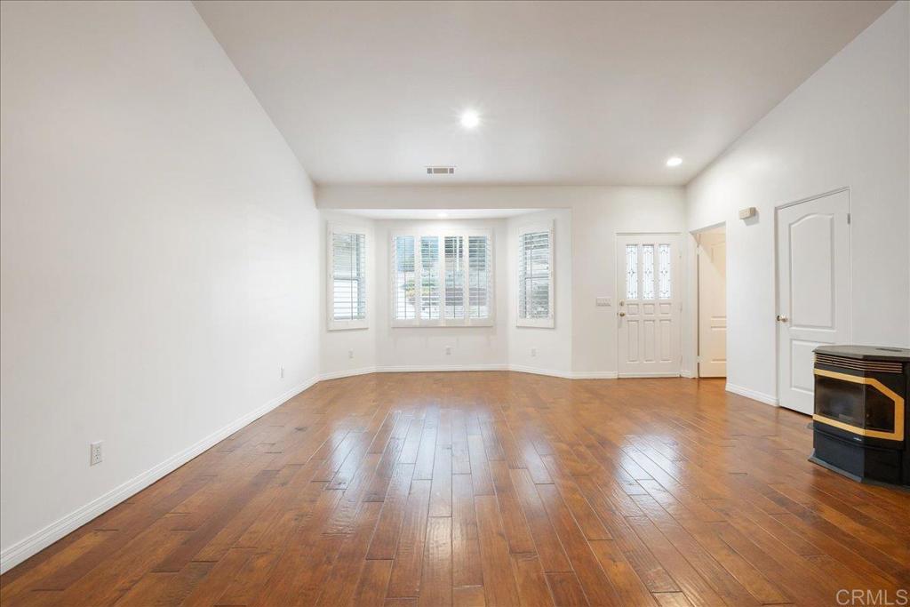 9144 Old Castle Road Valley Center, CA 92082 - Photo 8 of 48 an empty room with wooden floor and windows