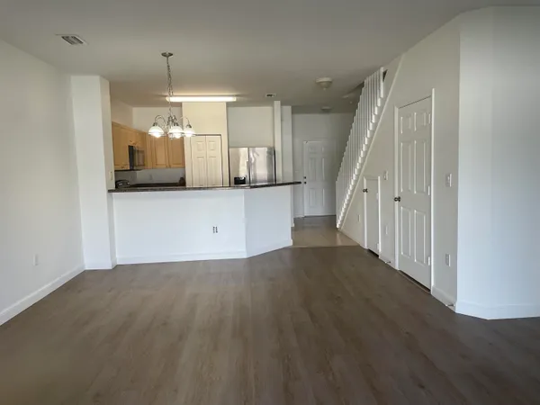 a view of a kitchen with wooden floor and electronic appliances