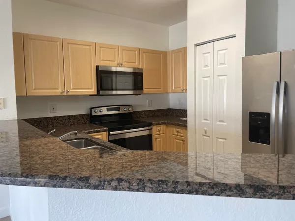 a kitchen with a refrigerator stove and cabinets