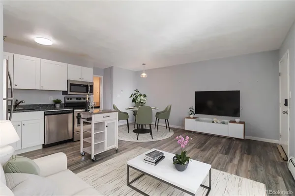 a living room with furniture a flat screen tv and kitchen view