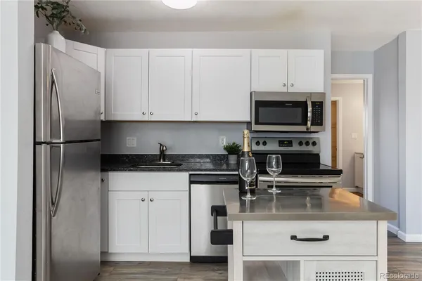 a kitchen with appliances a sink and cabinets