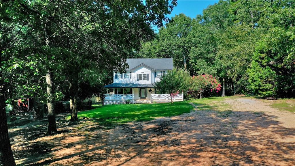 a front view of a house with a yard and a tree