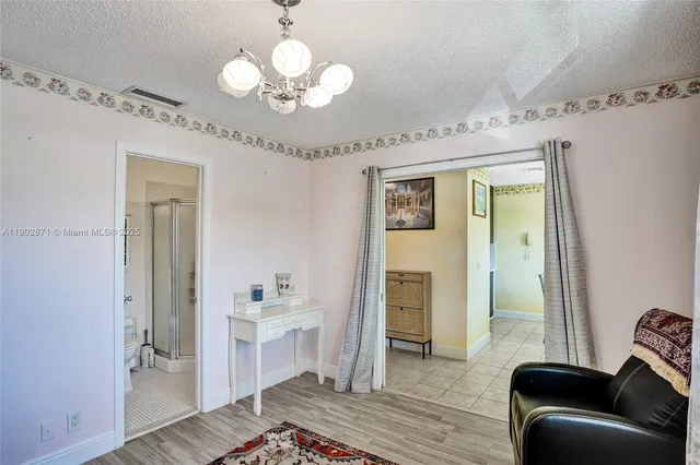 a spacious bedroom with a bed and a chandelier