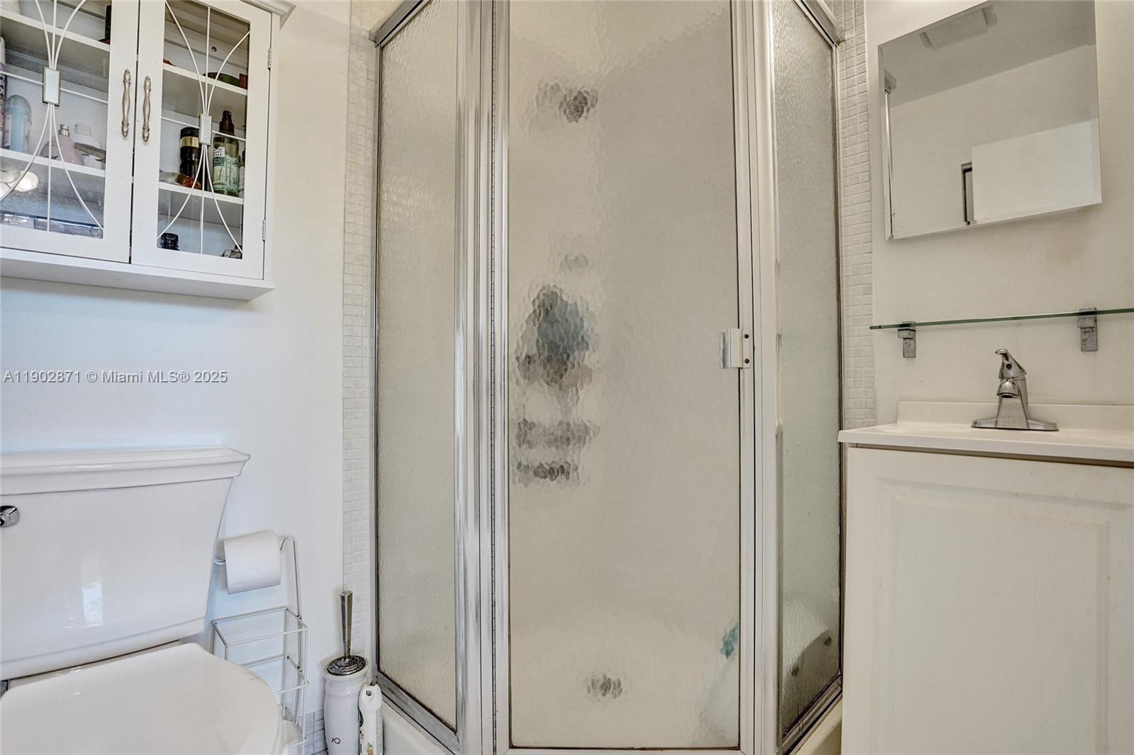 1450 Northwest 18th Avenue, Unit 203 Delray Beach, FL 33445 - Photo 22 of 30 a bathroom with a shower a toilet and sink