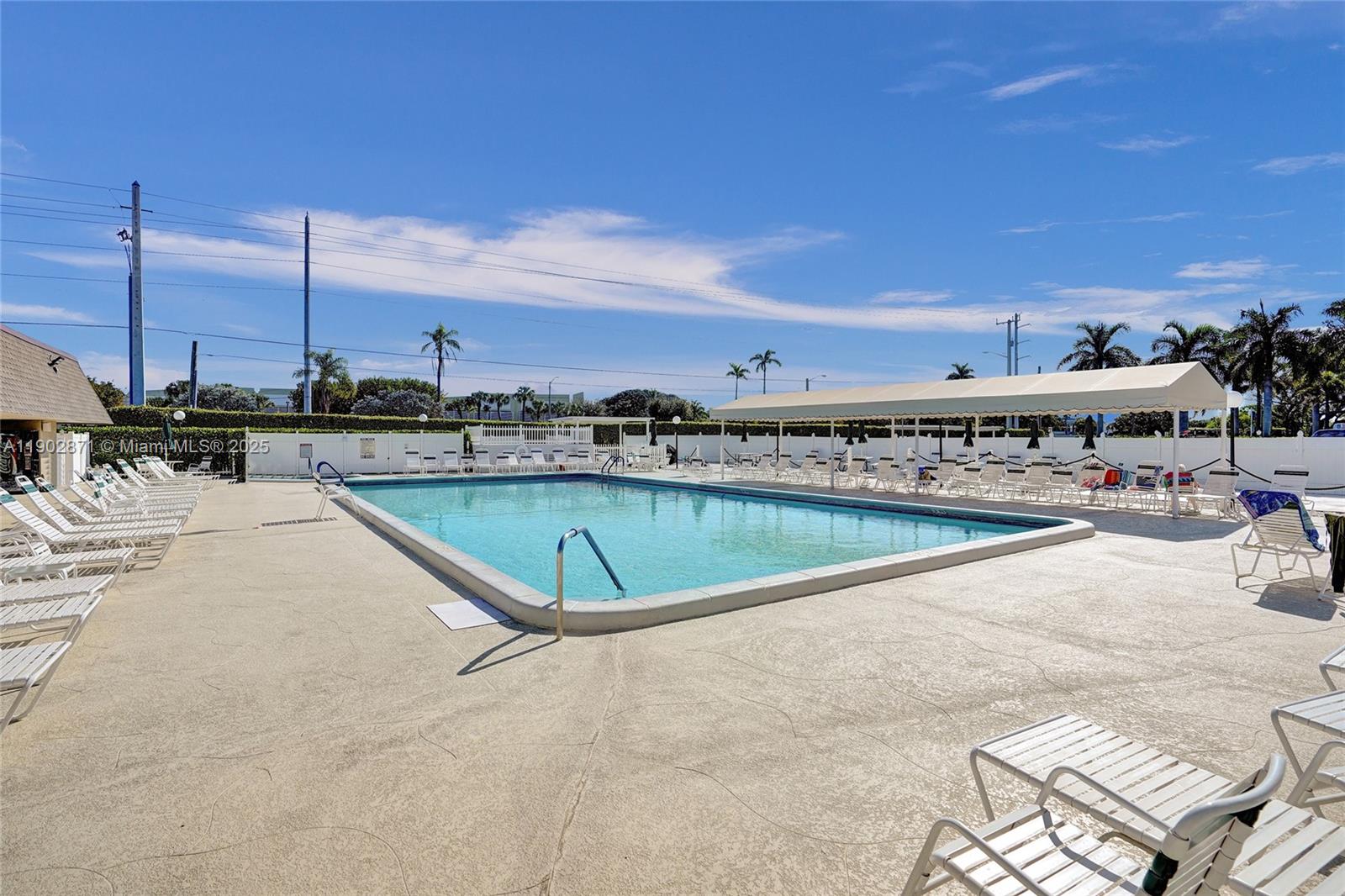 1450 Northwest 18th Avenue, Unit 203 Delray Beach, FL 33445 - Photo 24 of 30 a view of a swimming pool with a lounge chairs
