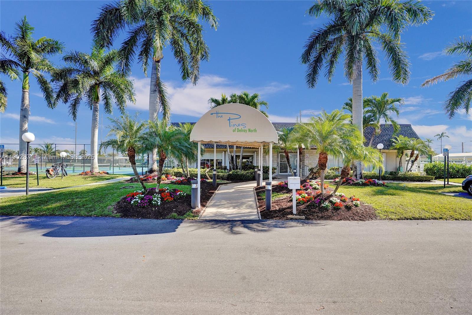 1450 Northwest 18th Avenue, Unit 203 Delray Beach, FL 33445 - Photo 27 of 30 a view of a park with a bench and trees