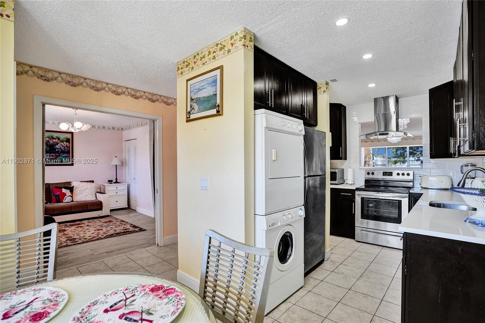 1450 Northwest 18th Avenue, Unit 203 Delray Beach, FL 33445 - Photo 4 of 30 a kitchen with refrigerator a sink and cabinets