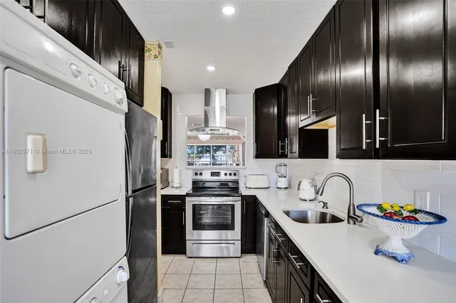 a kitchen with stainless steel appliances a sink stove and refrigerator