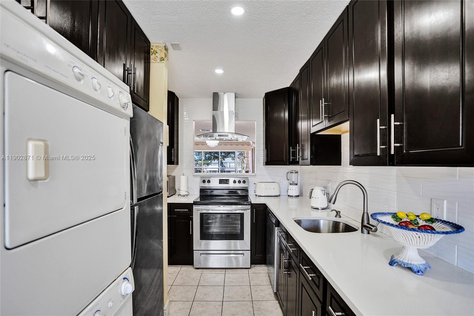 1450 Northwest 18th Avenue, Unit 203 Delray Beach, FL 33445 - Photo 5 of 30 a kitchen with stainless steel appliances a sink stove and refrigerator