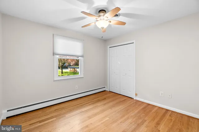 an empty room with a window and ceiling fan